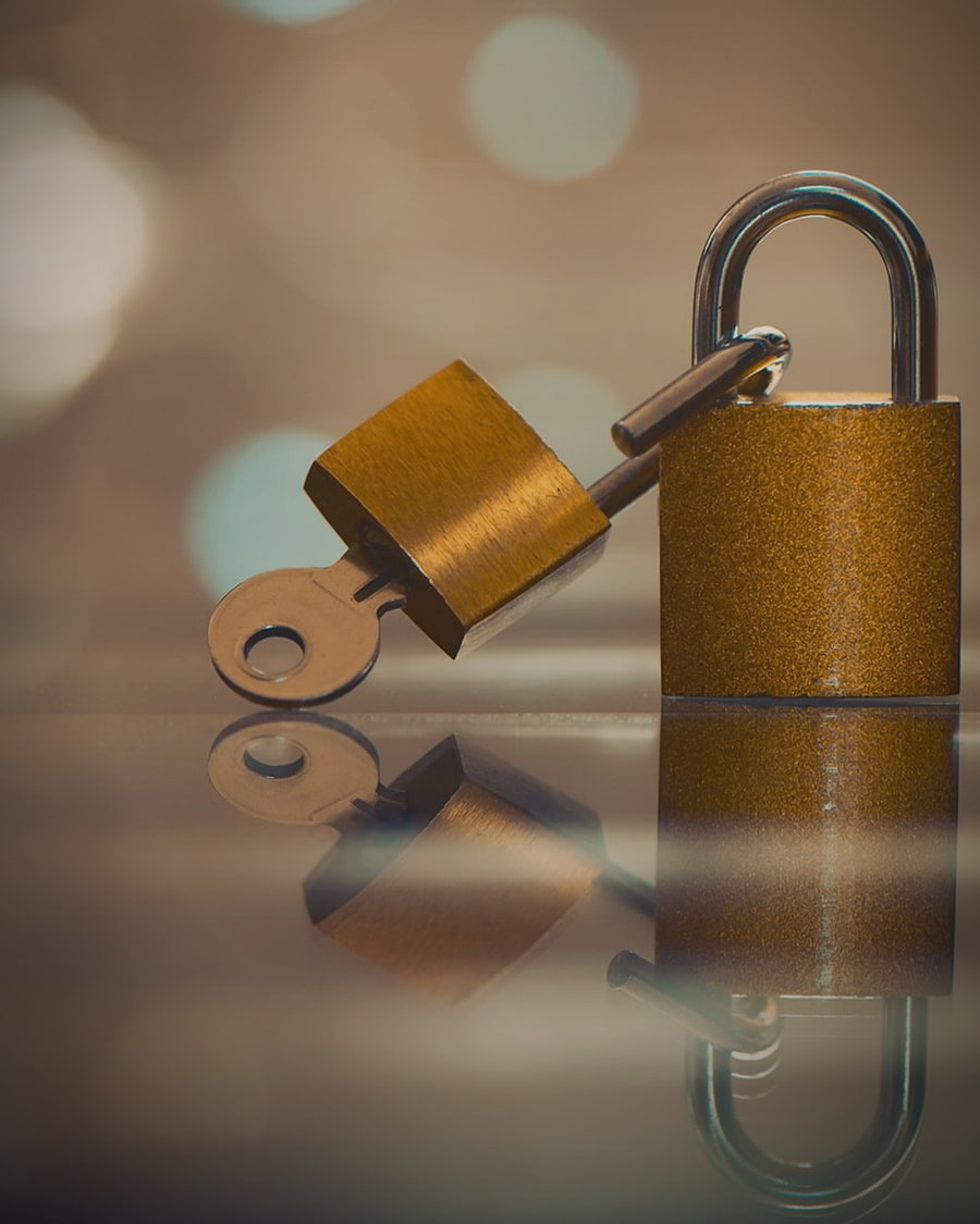 A golden padlock holding its key on a dark reflective surface: value that moves only when encrypted