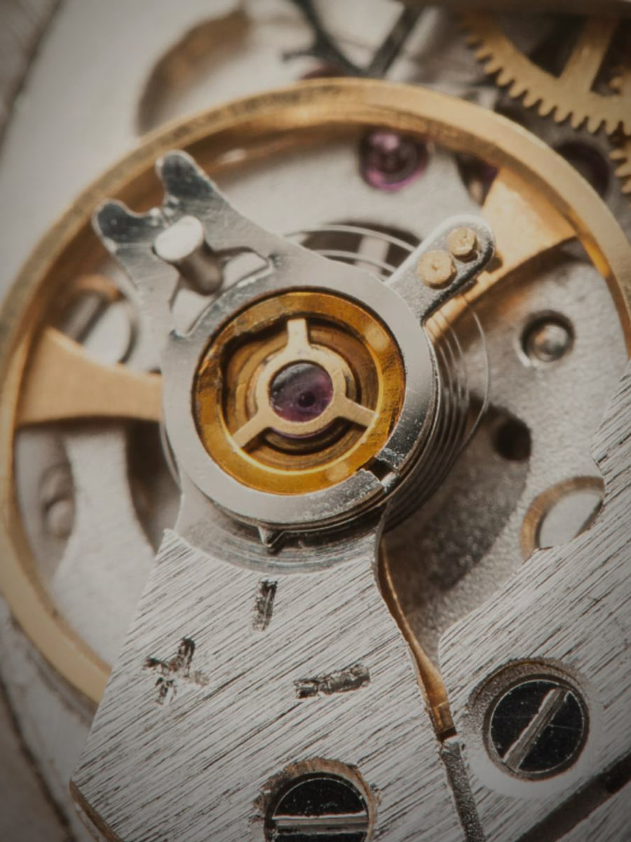 Macro of a mechanical watch movement, gears and jewel bearings: price feeds machined to precision